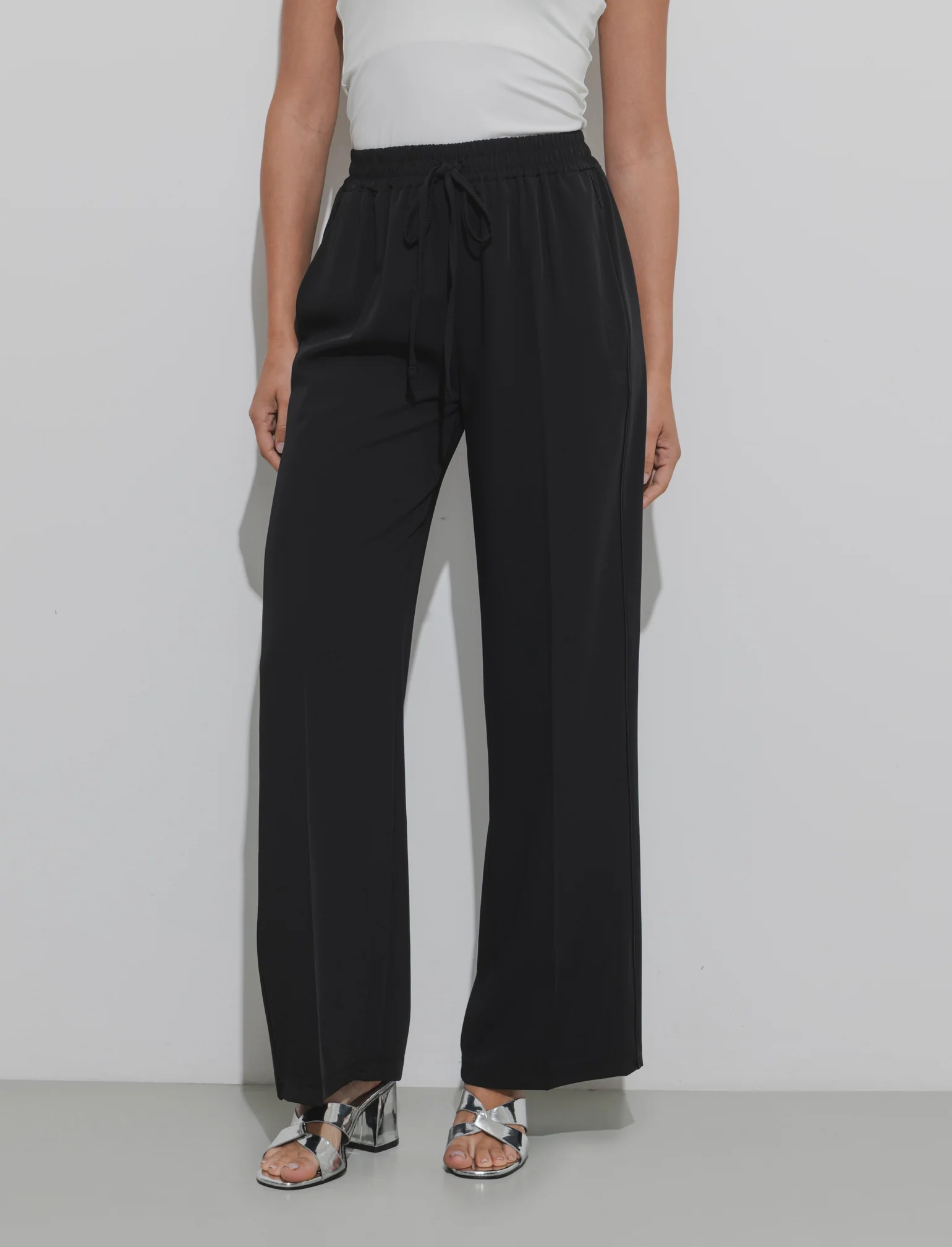 Pantalone palazzo con vita elasticizzata e coulisse regolabile. - Nero